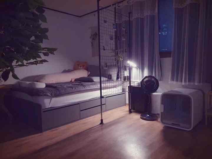 柔らかなナチュラルカラーの寝室、収納付きベッドと多機能な間仕切りが配置された雰囲気のあるインテリア