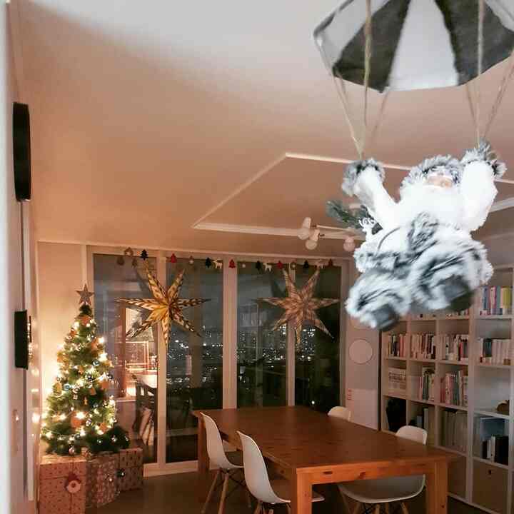 Ivory and wood-toned dining room featuring a decorated Christmas tree and garland, creating a warm festive atmosphere