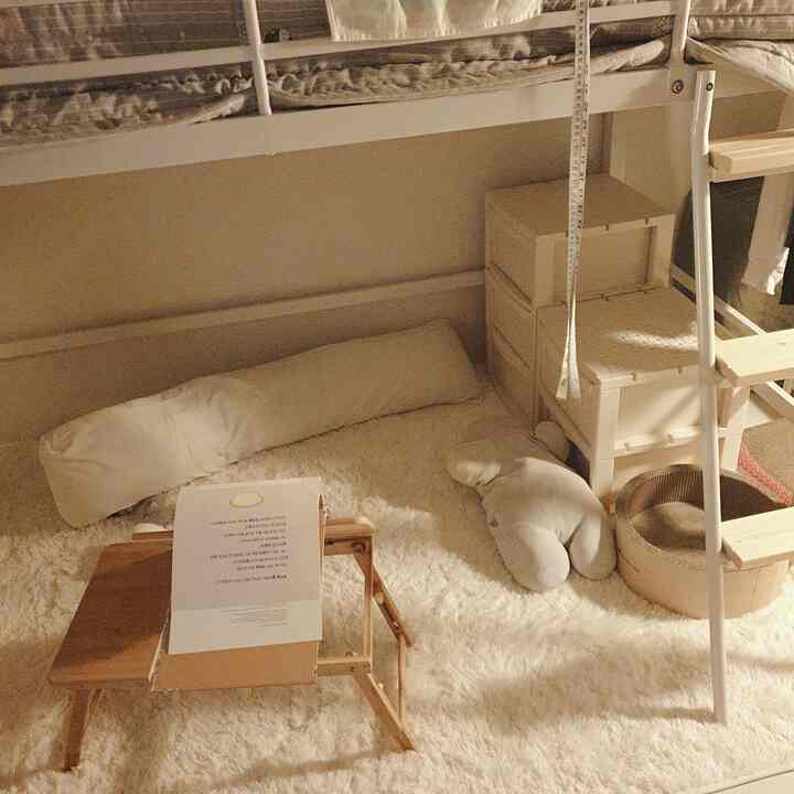 Soft natural-toned bedroom featuring a white metal bunk bed, microfiber rug, and rattan dresser creating a cozy relaxation space