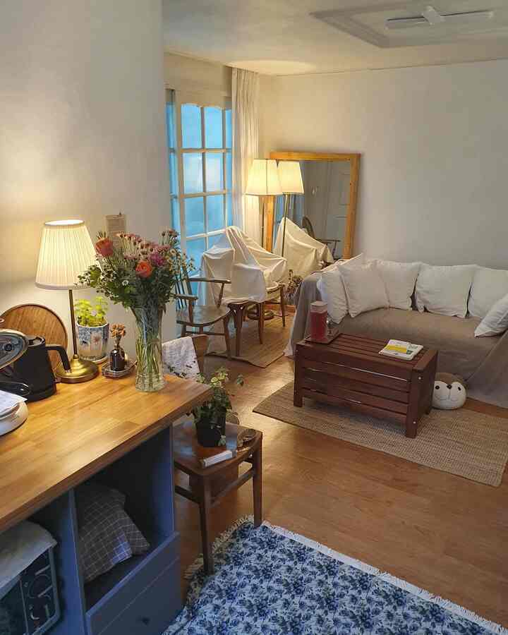 Natural color and white-toned living room featuring wood furniture and indirect lighting with a cozy home cafe vibe
