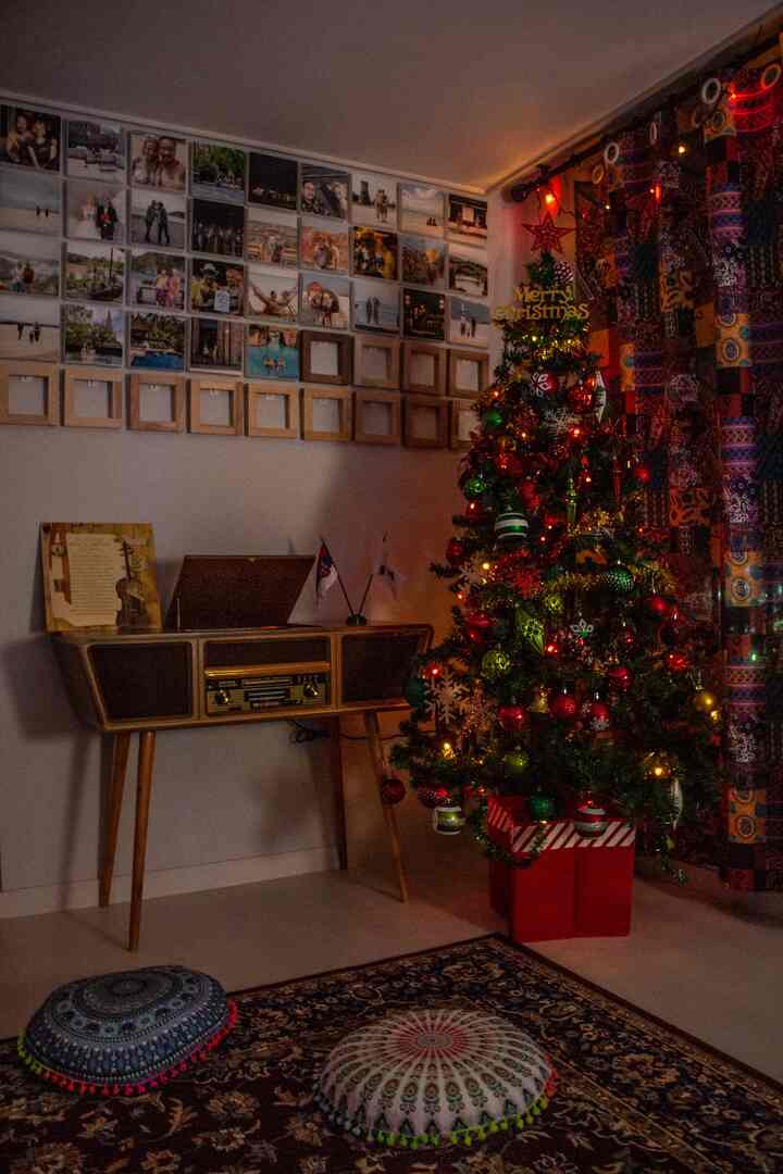 Charcoal and brown toned living room featuring a Christmas tree and vintage tube audio player creating a warm Bohemian atmosphere