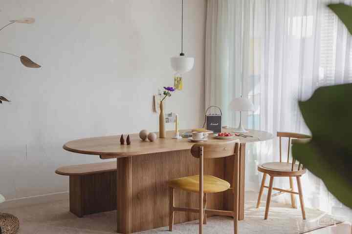 Bright white and wood-tone living room featuring natural dining table and chairs with cozy atmosphere