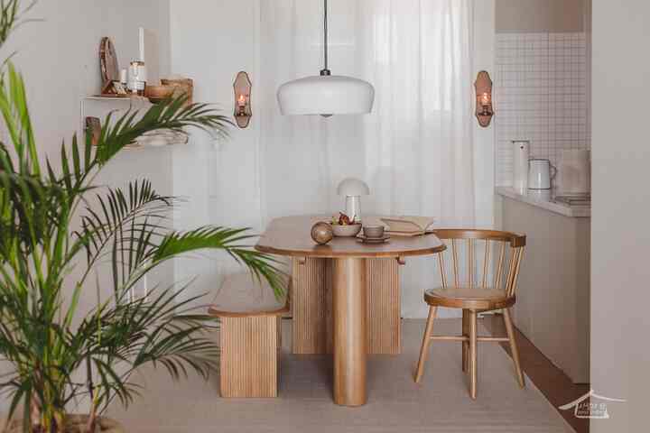 A natural and vintage kitchen space with white and wood tones, featuring a wooden dining table and chairs in a cozy atmosphere
