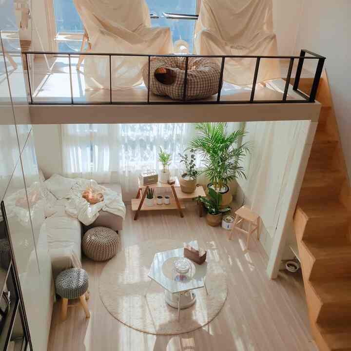 Bright natural-toned loft and living room space featuring cat bed and wooden stools with cozy interior