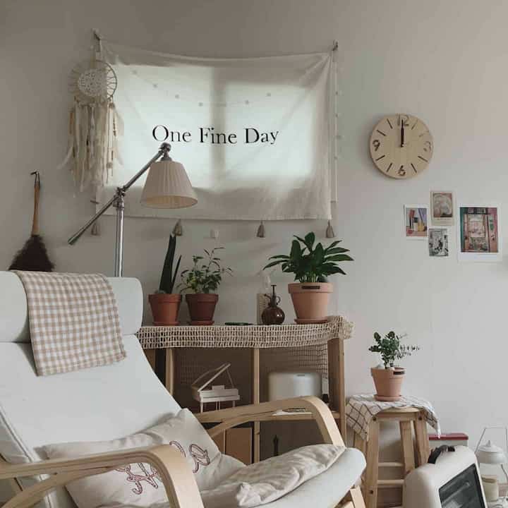 ナチュラルな色調のリビング、木製家具と多様な観葉植物が調和したシンプルで居心地の良いインテリア