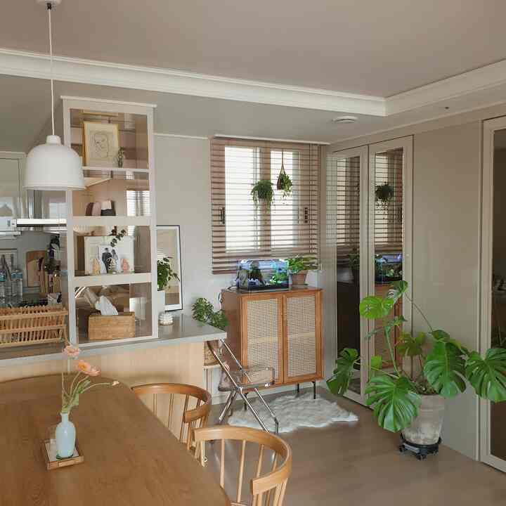 Soft natural-toned dining room with fish tank and plants creating a cozy relaxation nook
