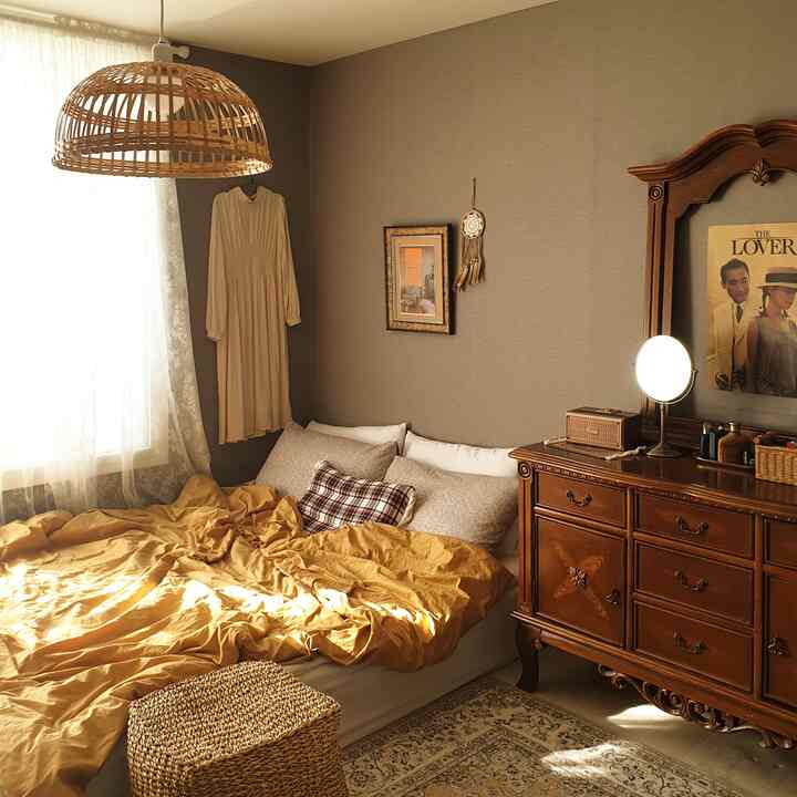 Warm beige wallpaper bedroom featuring rattan pendant light, vintage dresser, and cozy morning sunlight ambiance