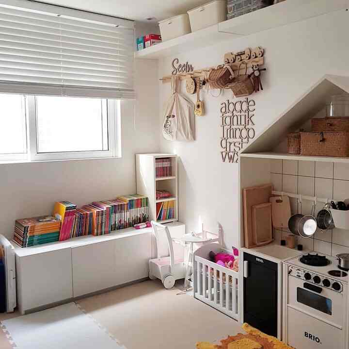 Clean white and natural tone kids' room featuring wall shelves and storage units with an organized atmosphere