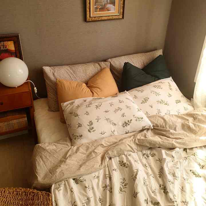 Beige and brown toned bedroom featuring floral fabric duvet cover and nightstand lamp with warm ambiance