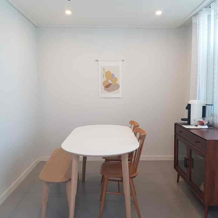 ホワイトと木目調の調和が取れたダイニング、ダイニングテーブルとベンチ、キャビネットが印象的な雰囲気のあるインテリア