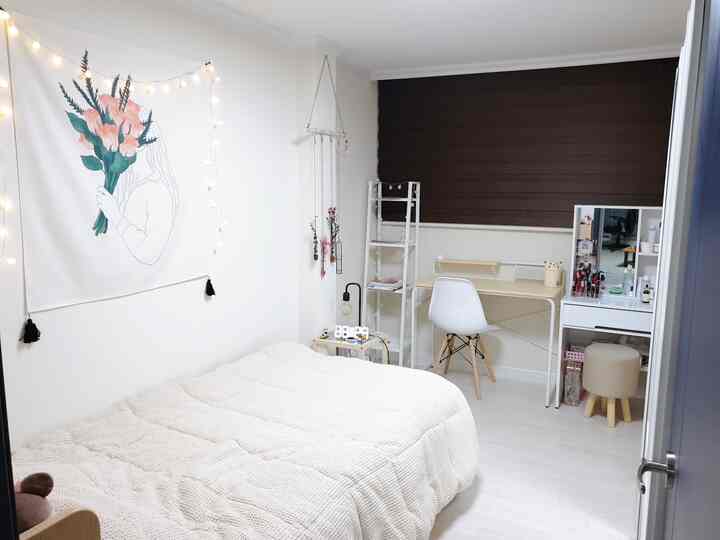 White and brown toned bedroom featuring a cozy bed and a neat desk with organized elements