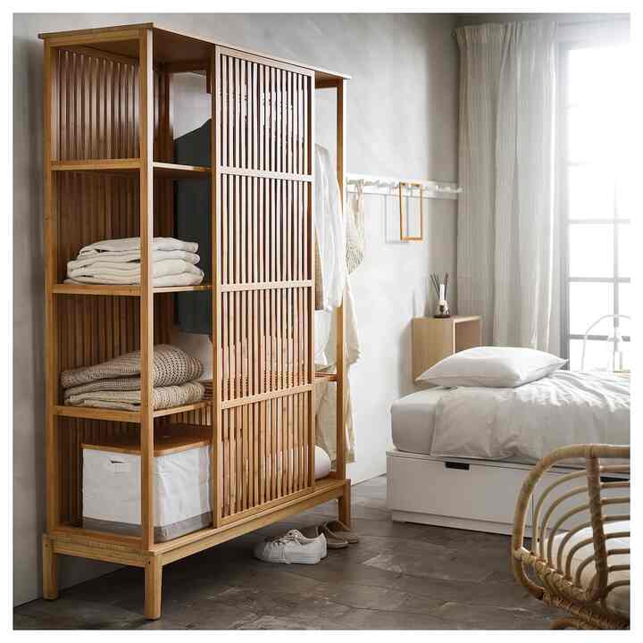 Bright white and beige toned bedroom featuring a bamboo wardrobe on the left, creating a natural modern space