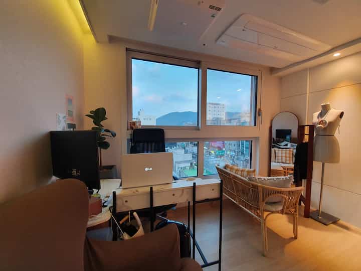 Warm orange lighting natural tone living room home office featuring rattan sofa and office chair in a cozy atmosphere