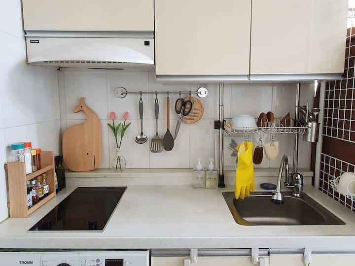 White and beige toned 3.5-4 pyeong studio kitchen featuring organized utensils and vase, practical compact space