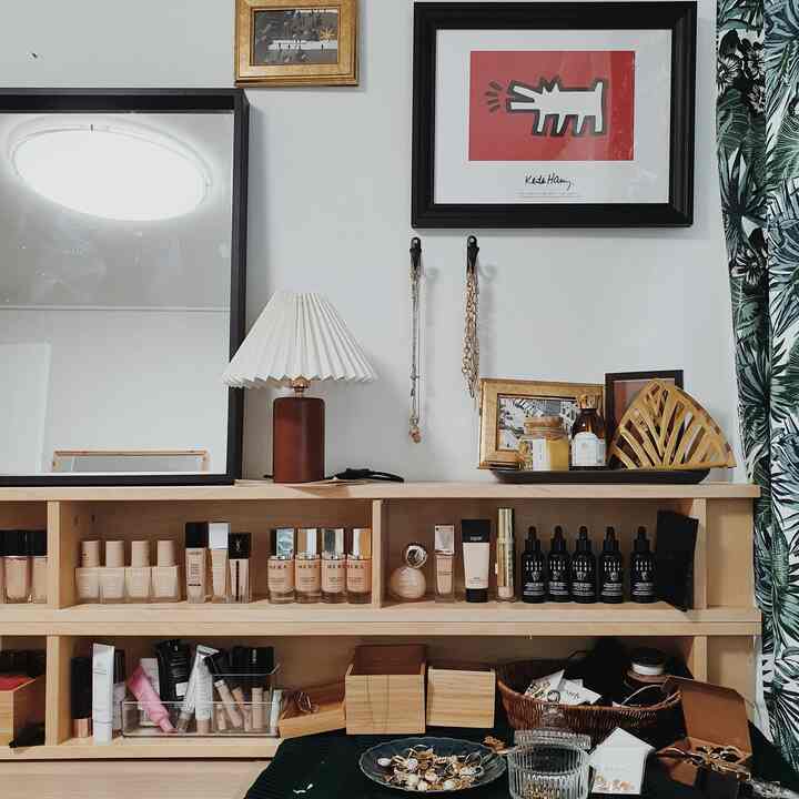 Wood tone vanity-centric interior space with wall art and table lamp creating a warm, organized atmosphere
