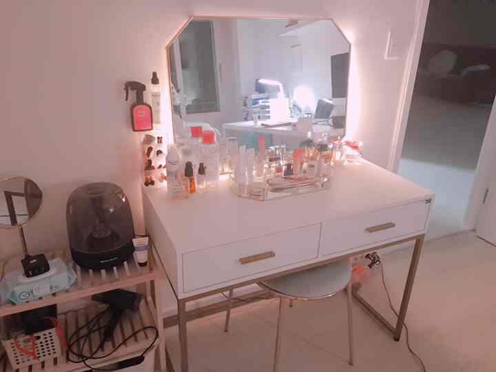 Natural style vanity and mirror in white and gold tones in a cozy small room setting with warm lighting