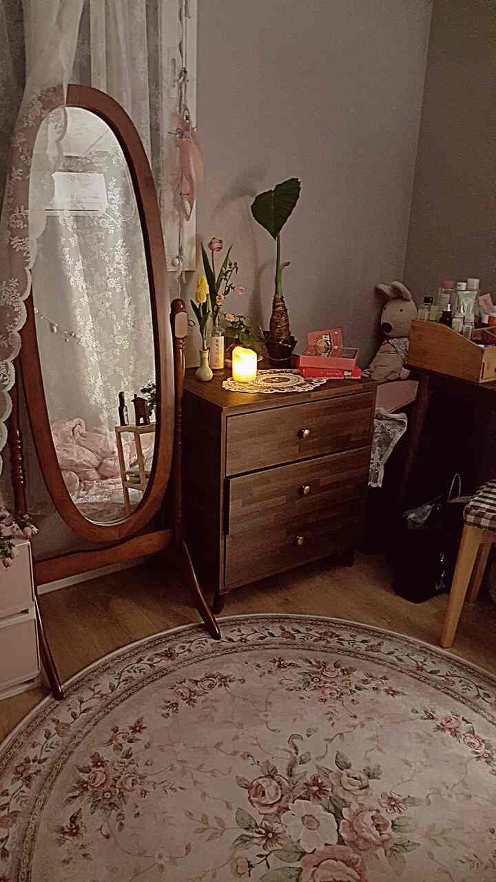 ナチュラルトーンの木製全身鏡と3段チェストが配置されたヴィンテージスタイルのワンルームインテリア