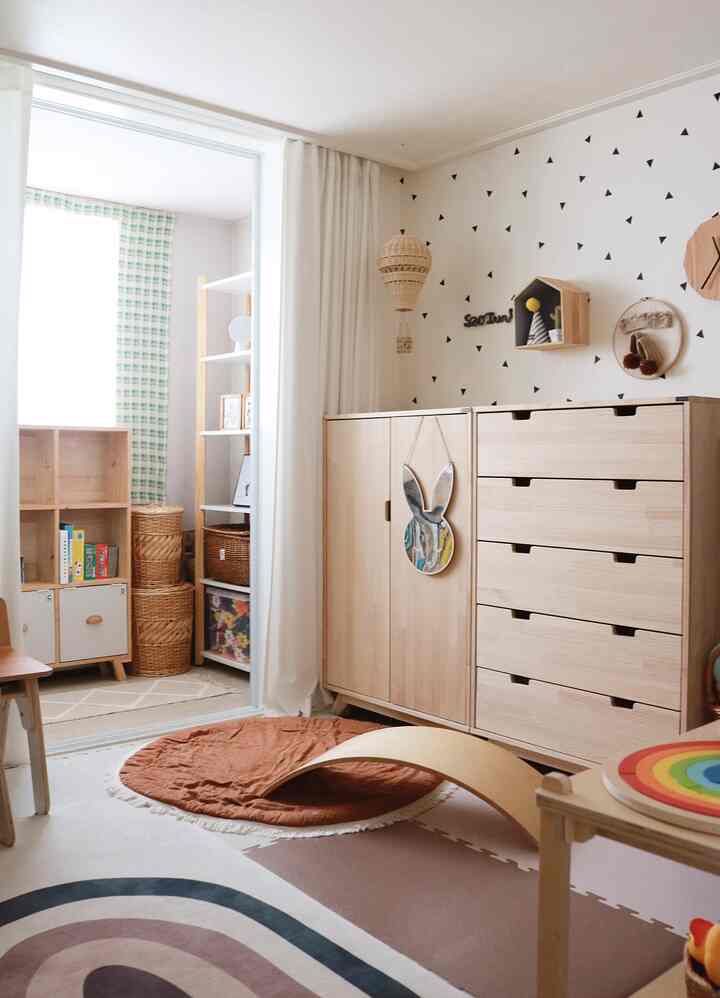 明るい木目調のナチュラルな素材を使ったベランダの子供部屋、収納家具とラグが配置された雰囲気のあるインテリア