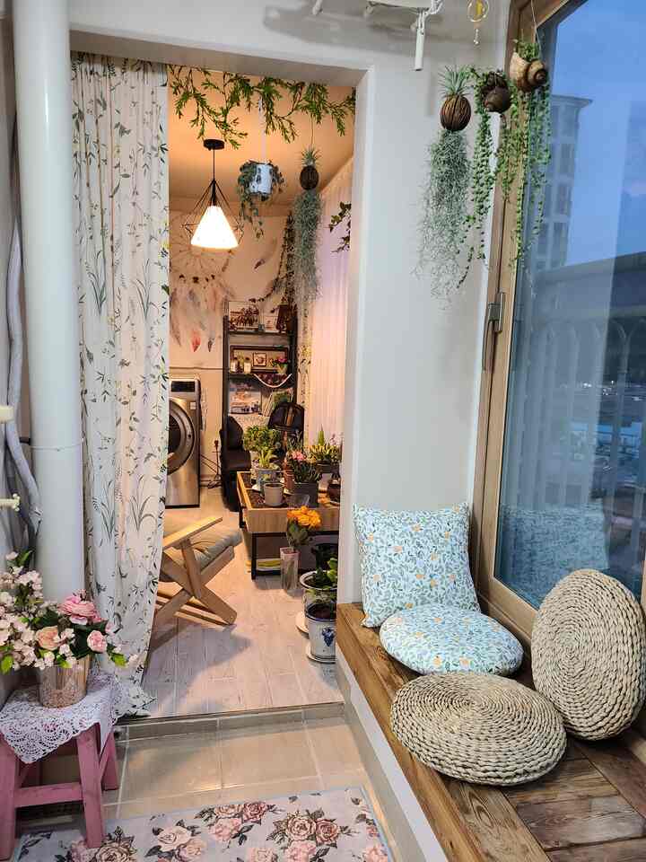 Natural wood tone and white-toned veranda featuring diverse plants and rattan cushions creating a cozy space