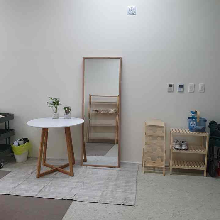 White and beige tone entrance featuring wooden furniture and a large full-length mirror with a natural atmosphere