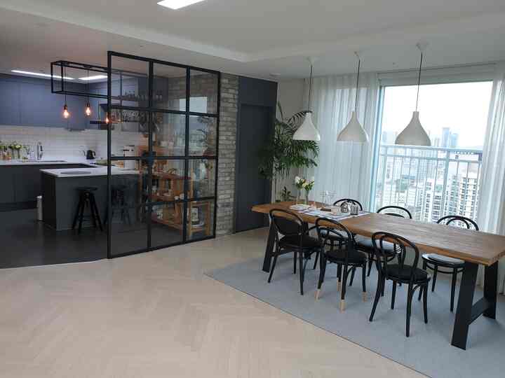 白と木目調の調和が取れたダイニングルームとキッチン、大きな窓とガラスパーティションで開放感のあるモダンなインテリア
