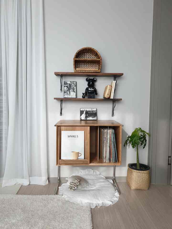 White curtains and natural wood furniture against a wall, featuring rattan accents and a green plant for a clean interior