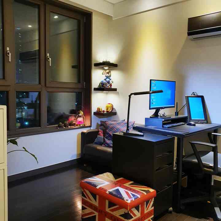 Dark brown and black toned study featuring a desk and armchair by large windows with city night view, accented by warm ambient lighting
