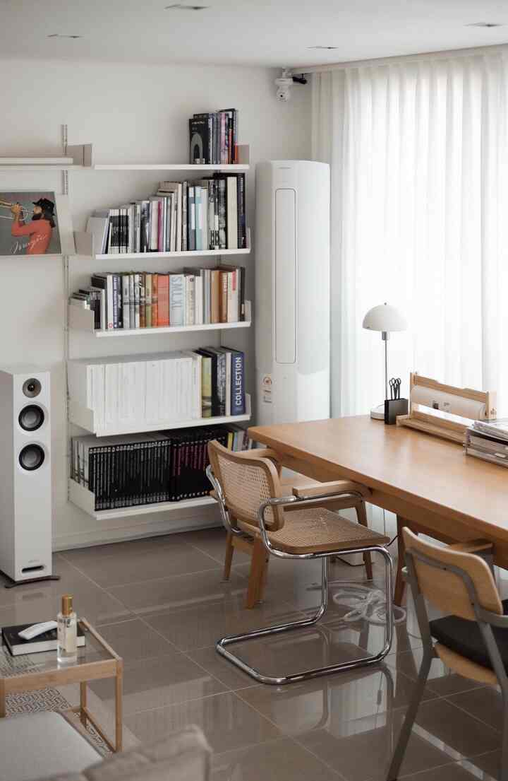 白と木目調の調和した書斎空間、本棚とモダンな家具が配置された印象的なインテリア