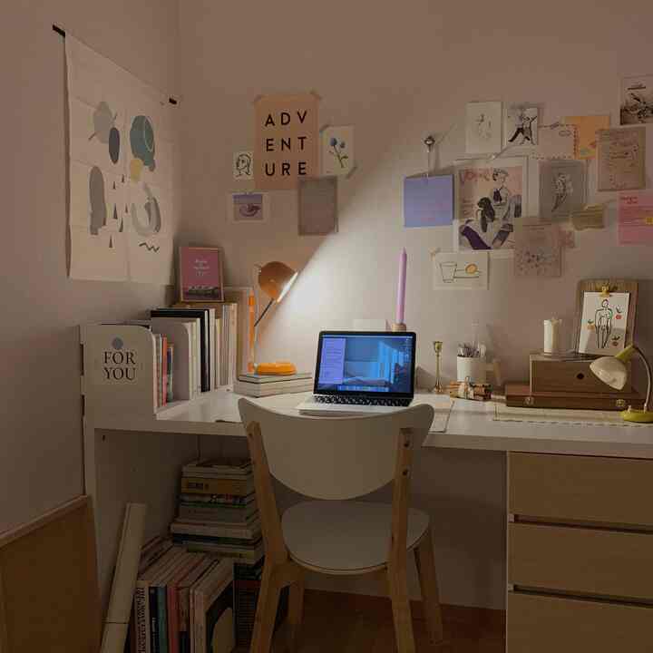 White and brown wood tone study space featuring a desk and art posters creating a cozy and calm atmosphere