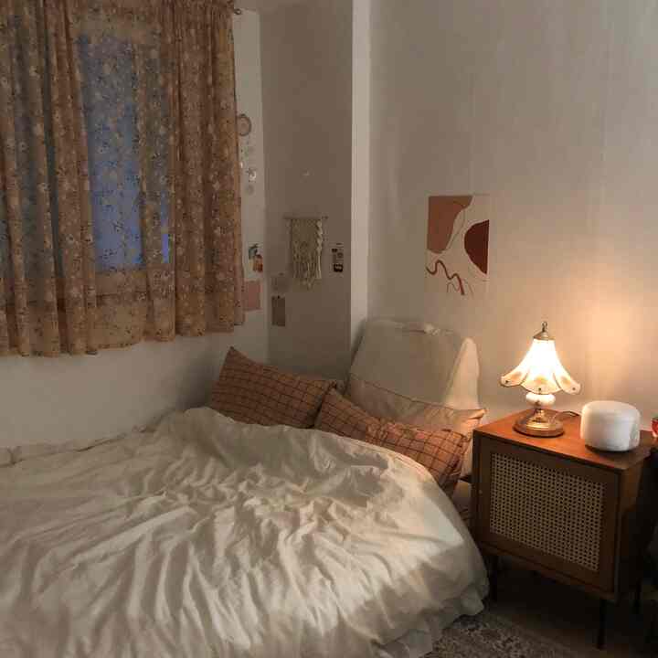 暖かいベージュ調の寝室、ベッドと照明付きのナイトテーブルが居心地の良い雰囲気を演出するインテリア