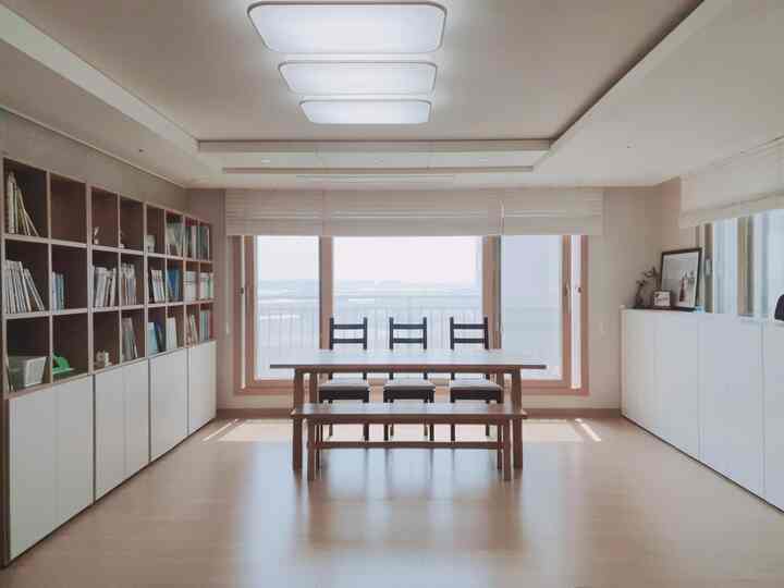 白と木目調のダイニングルーム、シンプルな収納と本棚が配置された雰囲気のあるインテリア