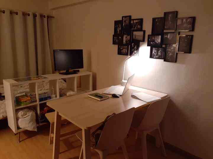 Natural brown and white toned small room home office featuring desk and shelving dividing the space