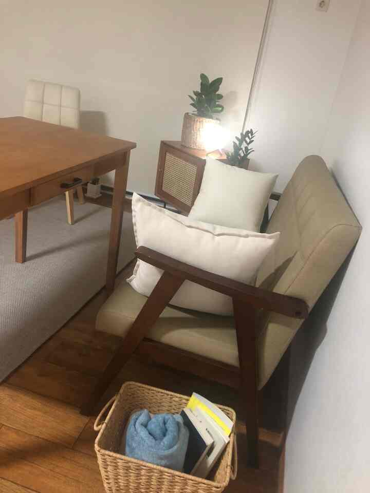 ナチュラルな木目調とベージュの色合いが特徴のシンプルで北欧風のダイニング、木製テーブルとクッション椅子が配置された空間