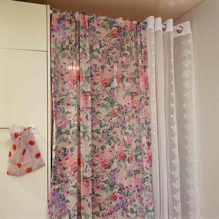 白と花柄のカーテンが配置された明るい窓辺の空間