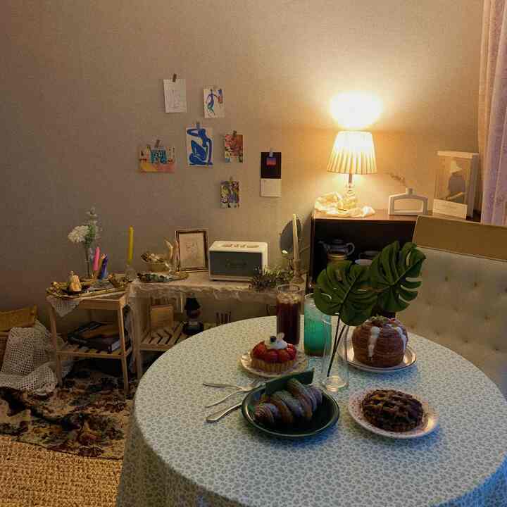 Warm beige-toned cozy dining room featuring floral tablecloth, vintage rugs, charming accessories and soft lighting
