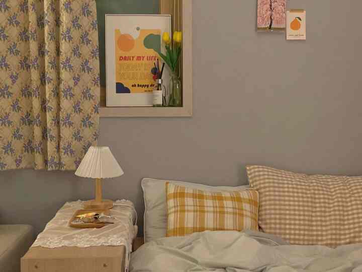 Calm yellow and beige toned bedroom featuring yellow check cushions and lace tablecloth on nightstand, natural modern style