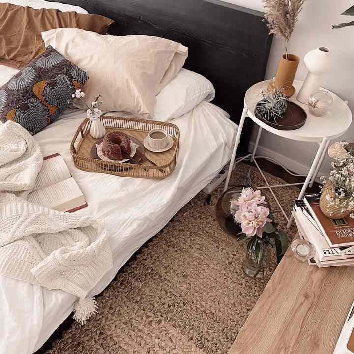 Natural-toned bedroom featuring rattan elements, vases, and a tray creating a cozy and warm interior atmosphere