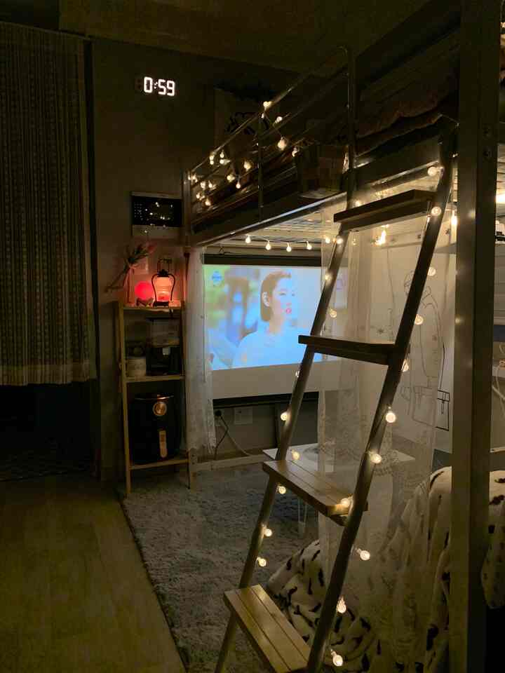 Cozy 5-pyeong studio apartment featuring a warm wood-tone bunk bed and projector screen, complemented by ambient decorative lighting