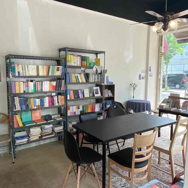 Bright natural-lit dining room with natural wood tones and black table creating a simple, clean atmosphere