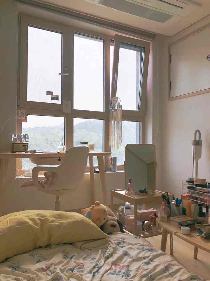 白と木目調が調和した一人暮らし用寝室、窓際にデスクと鏡が配置された落ち着いた雰囲気のインテリア