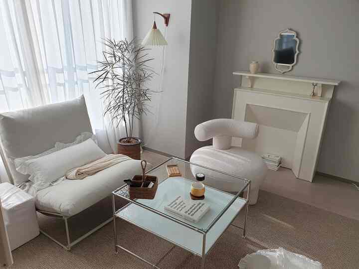 Soft beige toned living room featuring natural sofa and plant in a simple, cozy space
