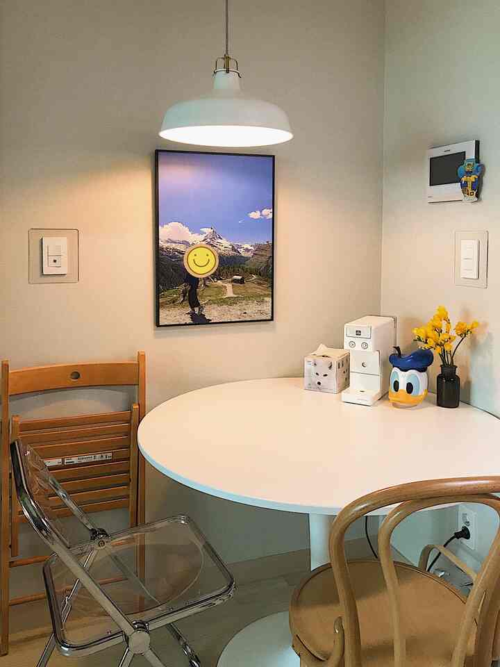 White and yellow toned kitchen featuring a round dining table with various chairs creating a cozy and clean atmosphere