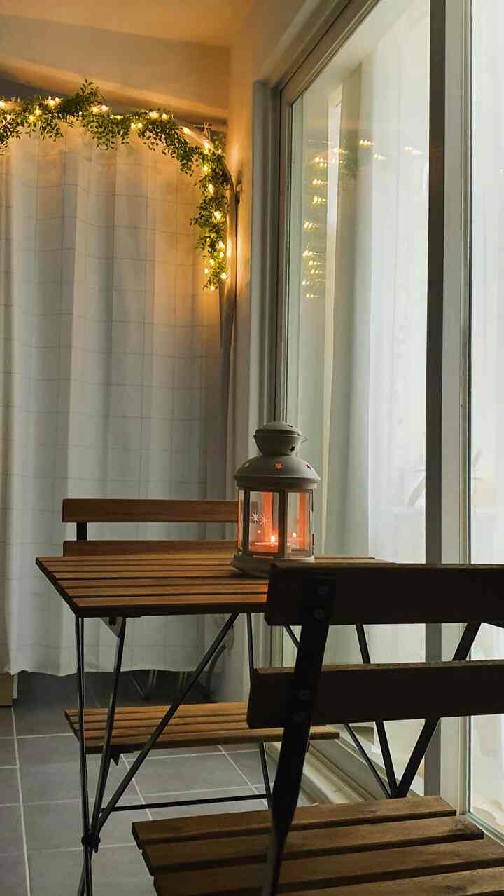 白いカーテンと茶色の木製家具が配置されたベランダのホームカフェ、居心地の良い暖かな雰囲気