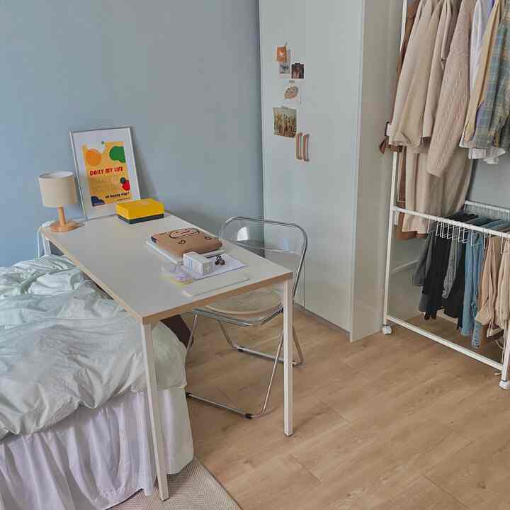 Natural modern tone single household room featuring white desk and transparent chair with a clean home office atmosphere