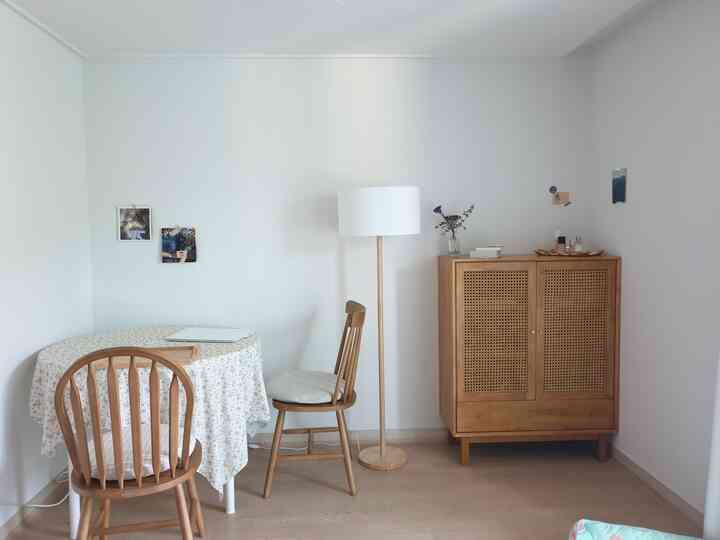 A simple and natural two-person living room with white walls and wood tone furniture