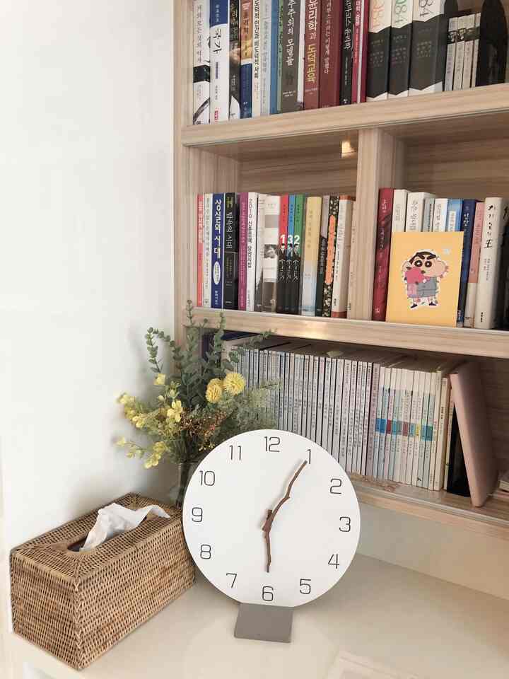 A bright study and multipurpose space with white walls and natural wood-tone bookshelf, featuring a clean and warm atmosphere