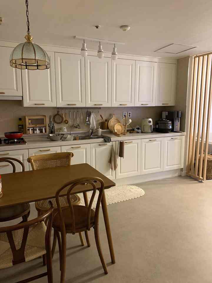 Natural wood tone and white kitchen space featuring a warm wooden dining table and chairs with a cozy atmosphere
