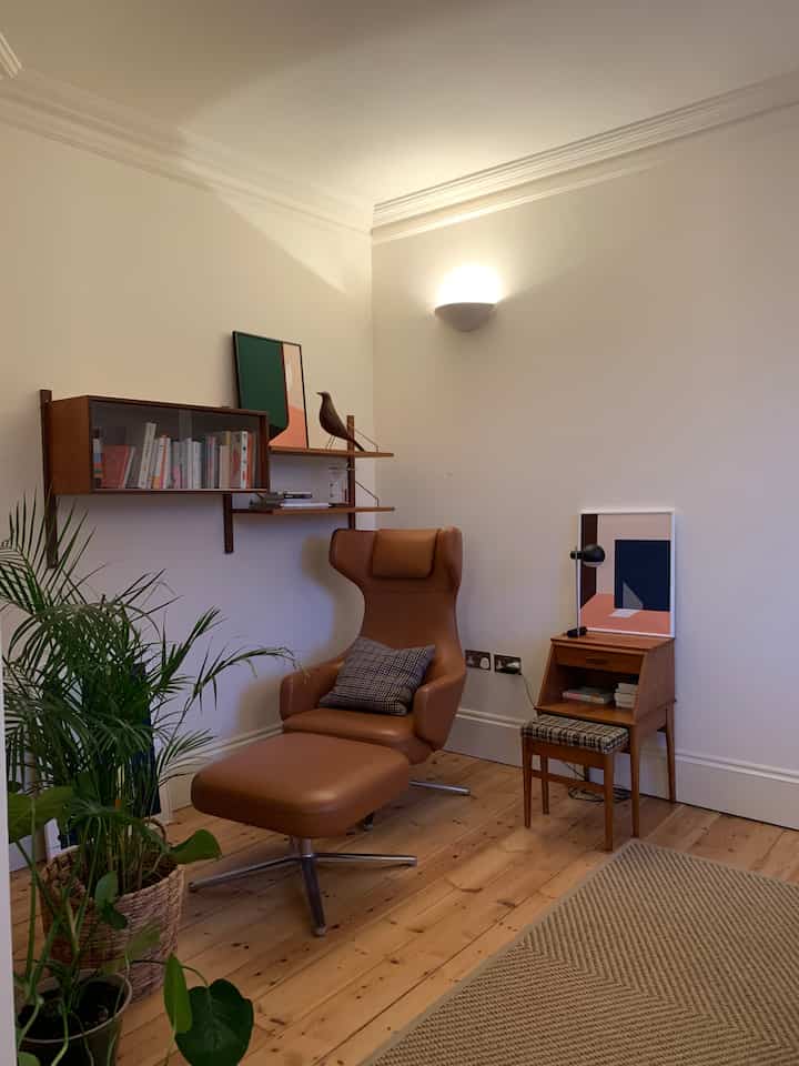 Natural wood-toned living room featuring leather recliner and plants with a cozy and comfortable atmosphere