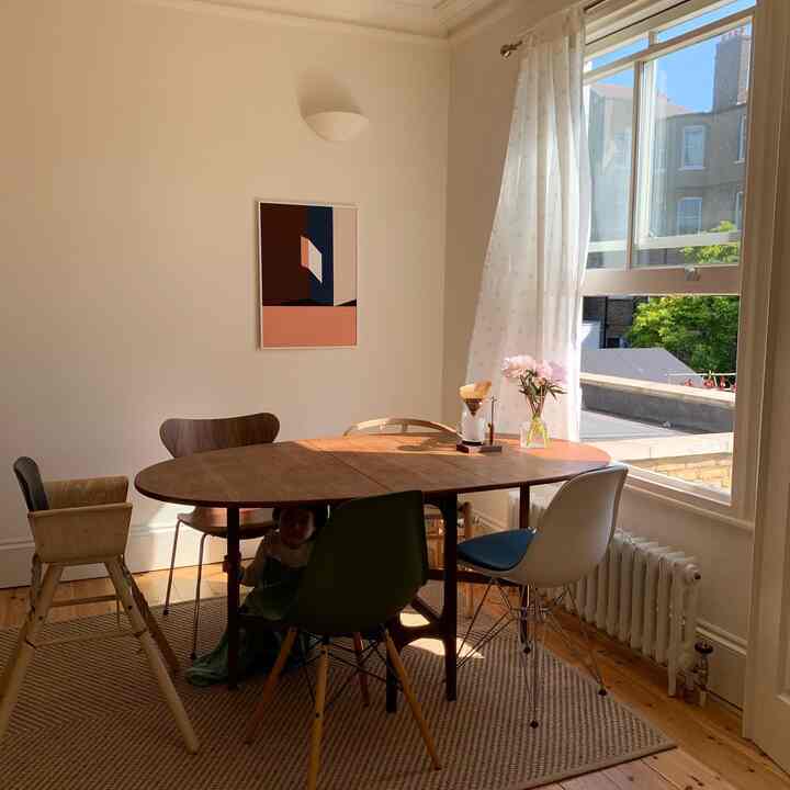 Beige-toned walls with wood-tone dining table, dining chairs, and curtains in a 4-person family dining room space