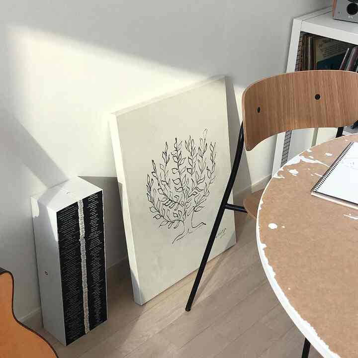 Natural-toned living room featuring a round dining table and wooden chair with cozy atmosphere